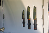 Organized GSI Outdoors knife set in an RV rental. Three black knives with orange handles and striped sheaths, perfect for cooking on the go.