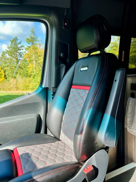Comfortable passenger seat in an rv rental, featuring black leather with red accents and a quilted pattern. Perfect for your next road trip.