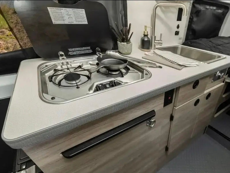  and controls. Compact and ready for travel.|Inside an RV rental camper van: a cozy dining area with table & bench — photo 8