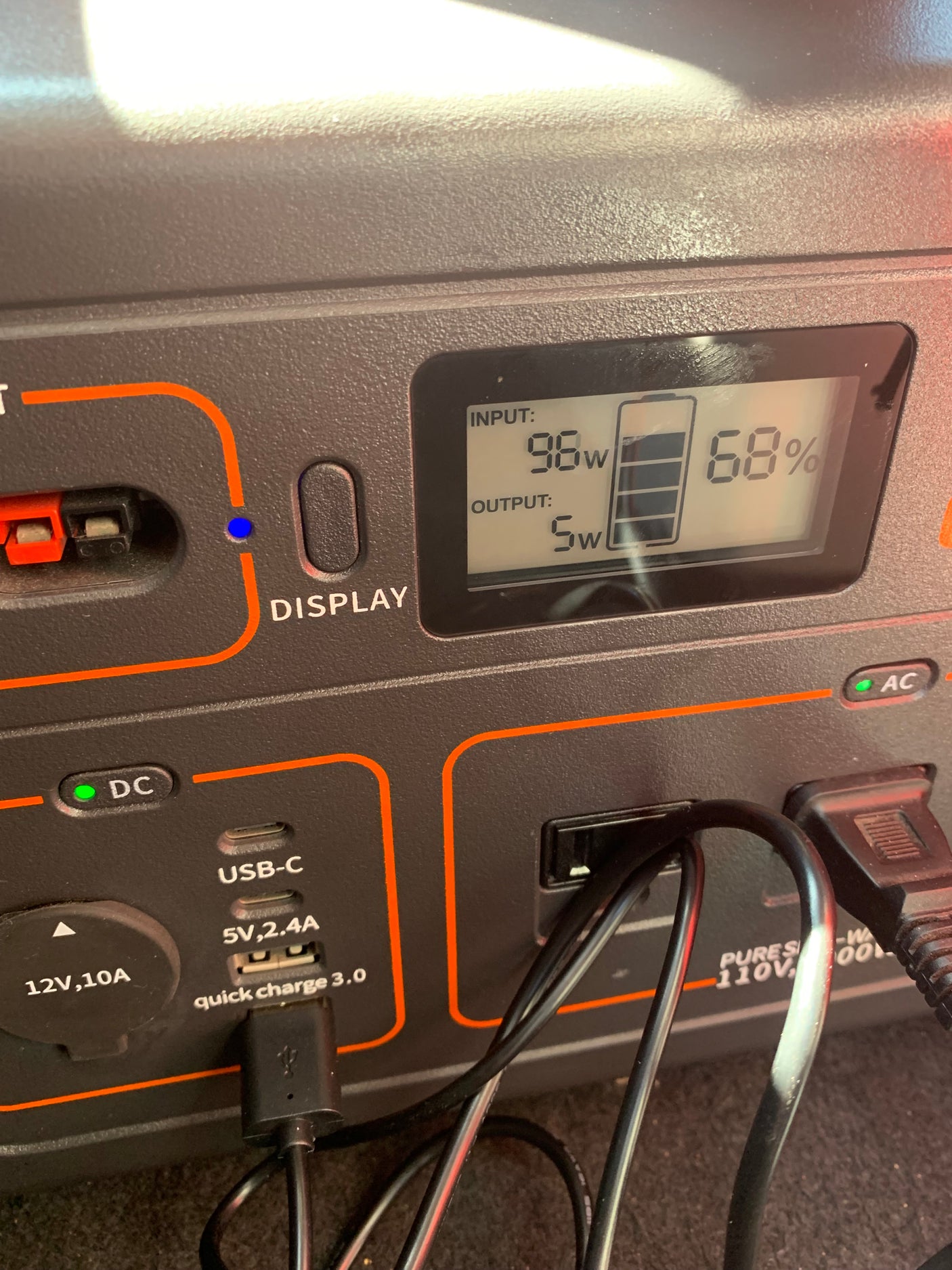 A portable power station in an RV rental, showing 68% battery, 98W input, 5W output, ideal for camping power needs.