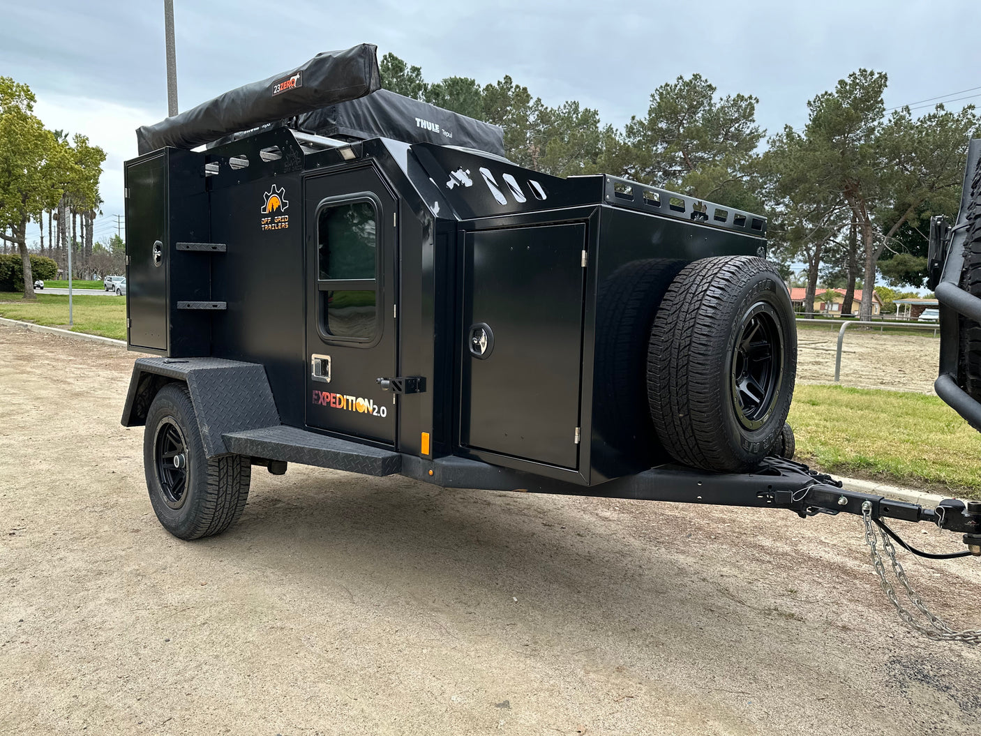 Adventure-ready Expedition 2.0 off-road camping trailer, a rugged RV rental alternative. Features rooftop tent and awning.