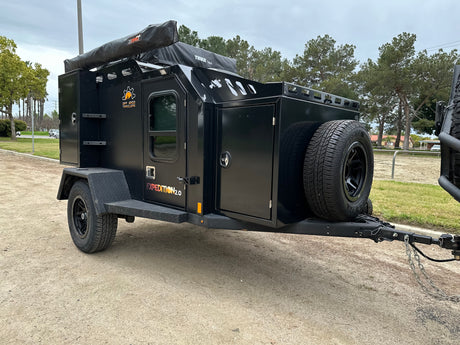 Adventure-ready Expedition 2.0 off-road camping trailer, a rugged RV rental alternative. Features rooftop tent and awning.