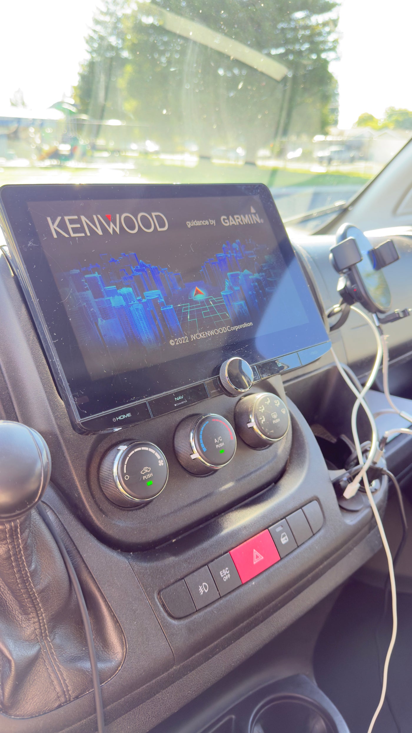 RV rental dashboard with Kenwood/Garmin navigation screen and climate controls, visible under bright sunlight. — photo 14