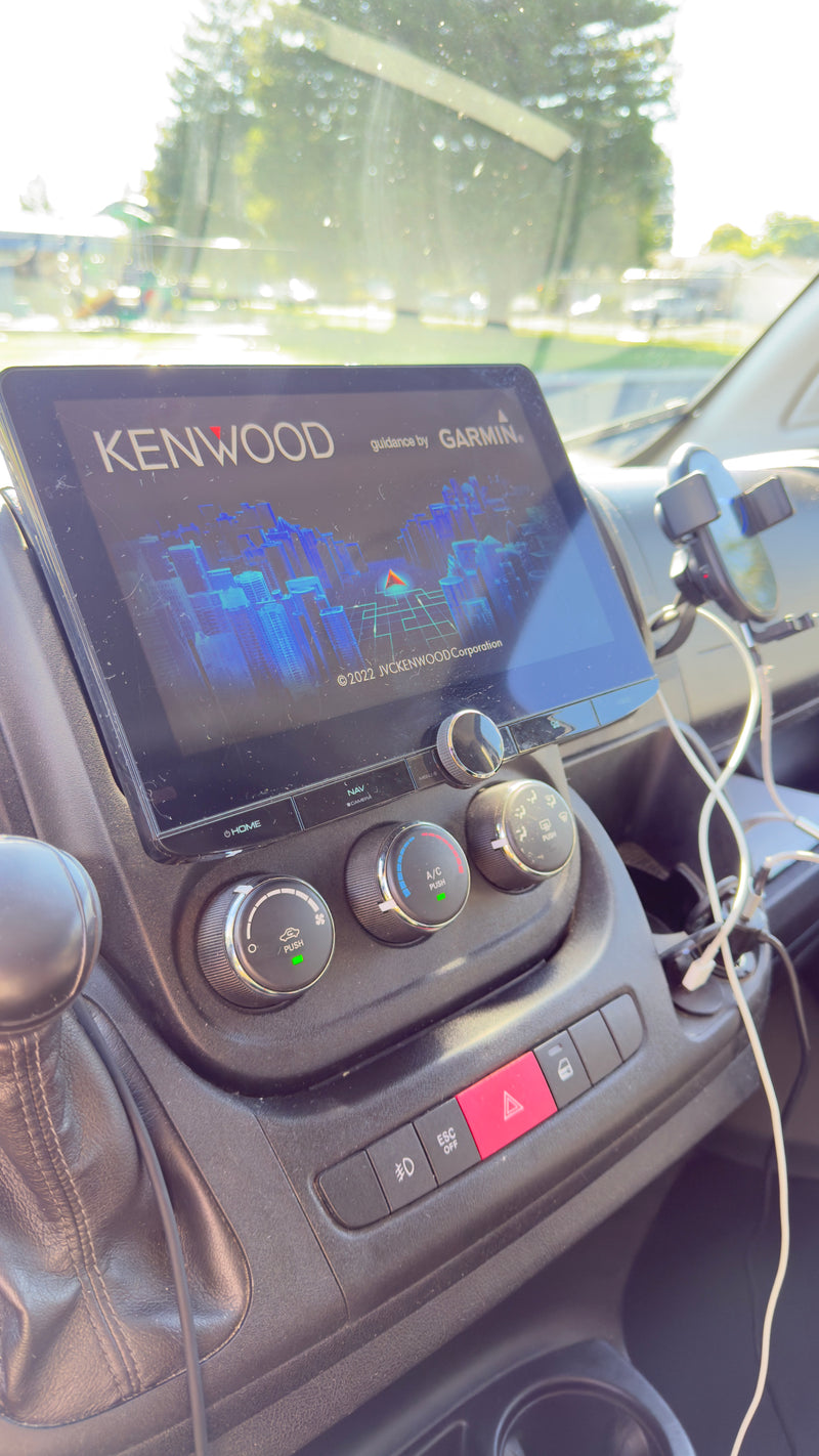 RV rental dashboard with Kenwood/Garmin navigation screen and climate controls, visible under bright sunlight. — photo 14