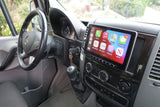 Inside an RV rental Mercedes-Benz Sprinter van: an upgraded Alpine Apple CarPlay screen, steering wheel, and controls are shown.