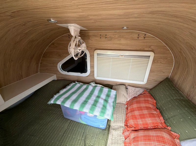  and windows.|Cozy RV rental interior features a comfortable bed with a green blanket — photo 8