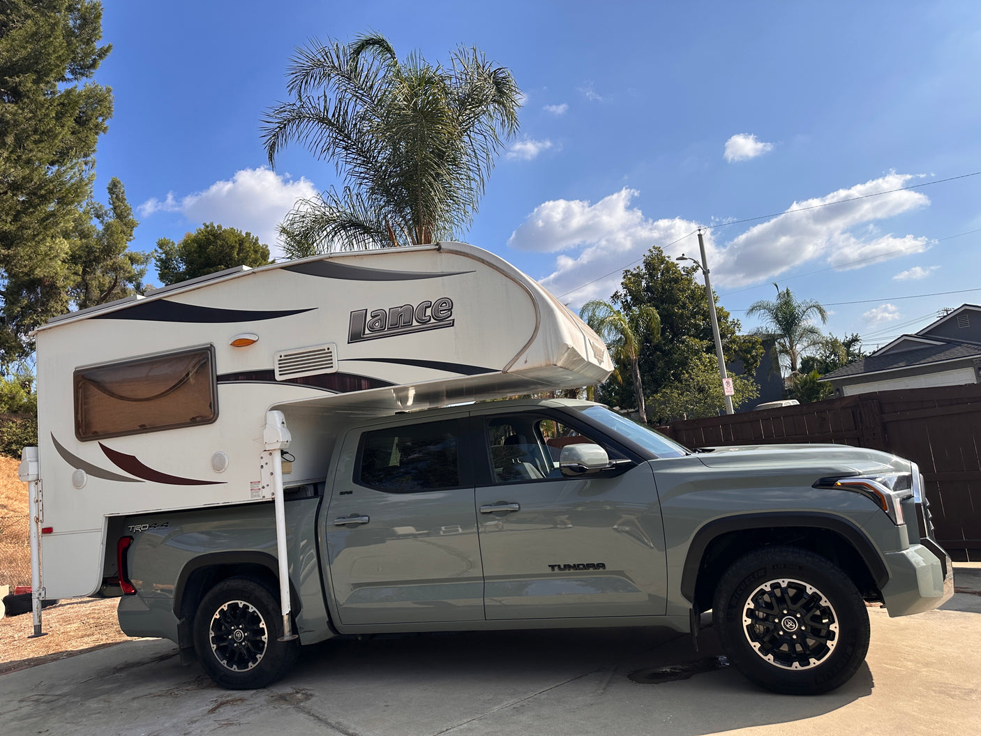 Grey Toyota Tundra truck with a Lance truck camper, ideal for an RV rental adventure or outdoor travel under blue skies.