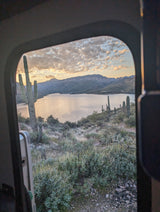 Stunning desert sunset from an RV rental, featuring saguaros, mountains, and a serene lake.