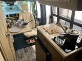 Explore an rv rental's interior: functional kitchen with stovetop & sink, dining space, and front cabin. Perfect for mobile living.