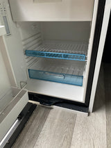 A clean, empty Dometic refrigerator interior, typically found in an RV rental, with shelves and control panel visible. Ready for use.