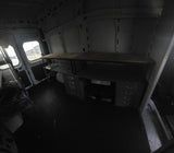 Interior of a cargo van, featuring a built-in desk & shelving, ideal for a custom RV rental conversion or mobile office.