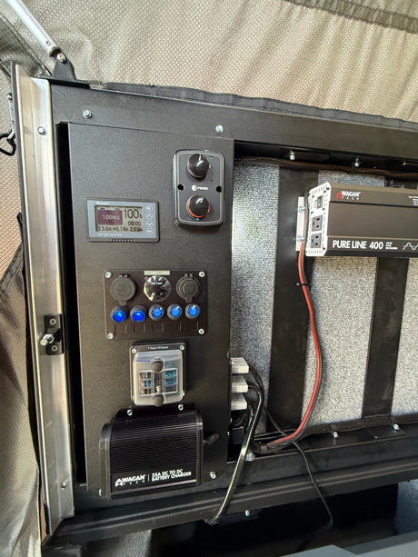 RV rental's integrated electrical panel, showing battery monitor, inverter, and charger for essential mobile power.