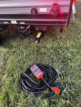 RV rental utility setup showing electrical connections, power cord with surge protector, and sewer/water outlets.