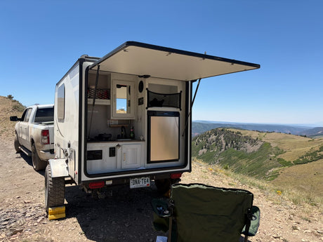 Enjoy an RV rental with an outdoor kitchen! This camper is parked on a mountain road