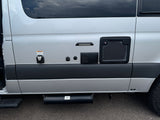 RV rental side: exterior utility hookups, water heater vent, and undercarriage sewer hose storage tube.