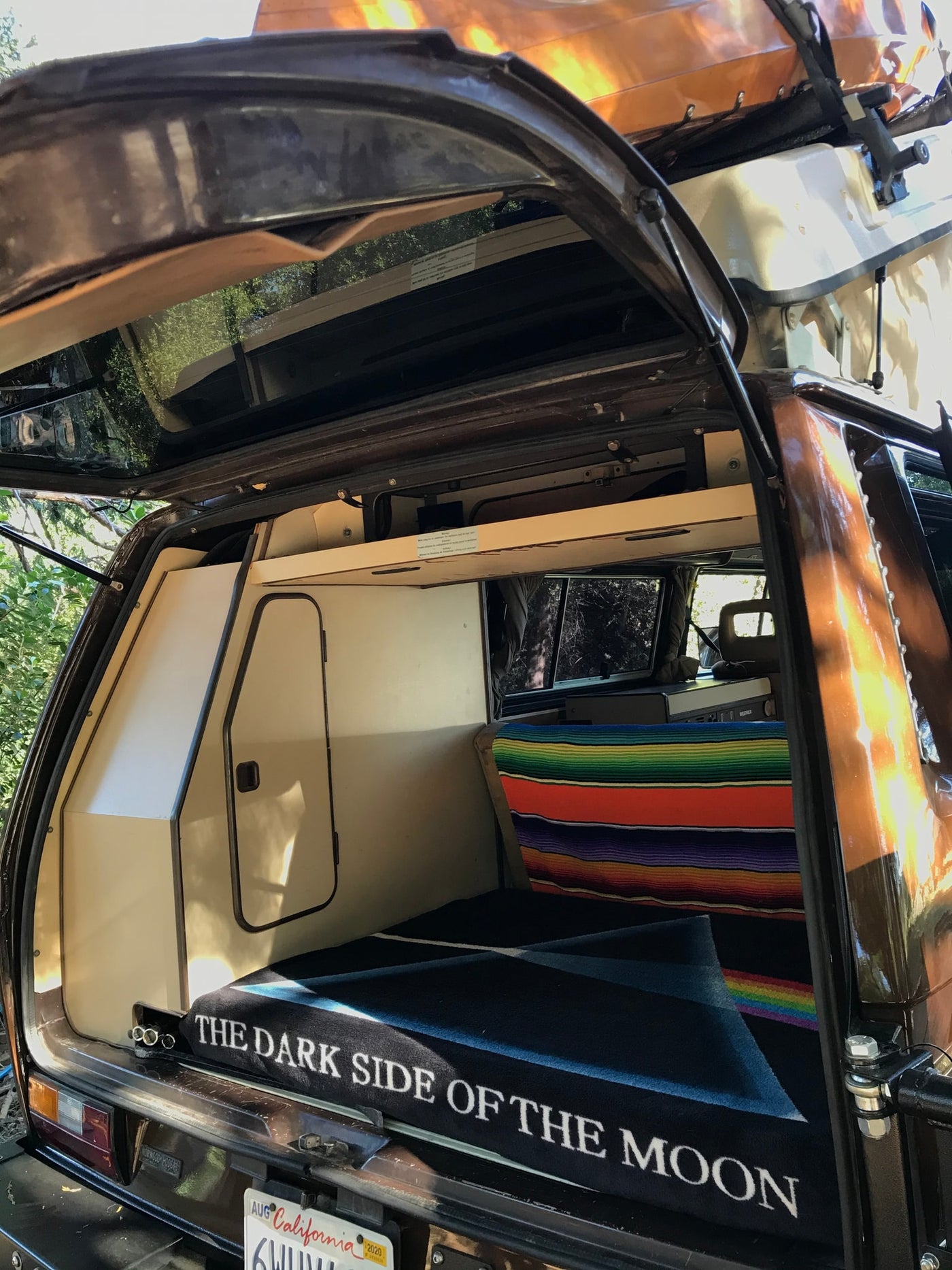  and warm wooden floor.|Inside this RV rental: a vibrant striped blanket on a bench — photo 15