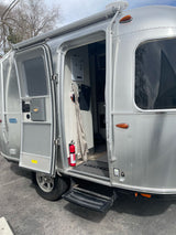 This silver Airstream Bambi RV rental has its door open, revealing the cozy interior, ready for adventure.