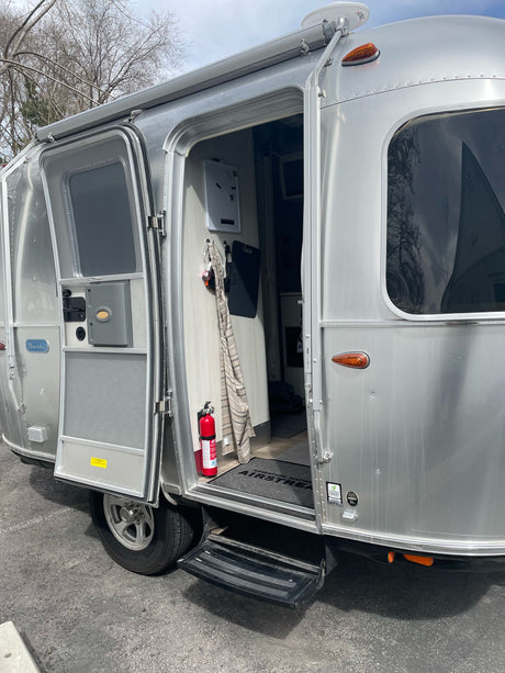 This silver Airstream Bambi RV rental has its door open, revealing the cozy interior, ready for adventure.