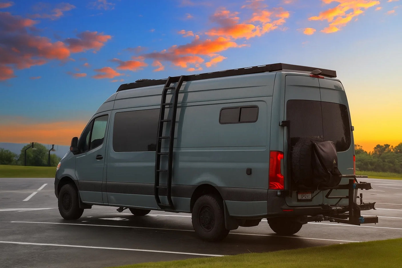 This custom teal camper van, with its ladder and rear bike rack, is ready for your next RV rental adventure at sunset.