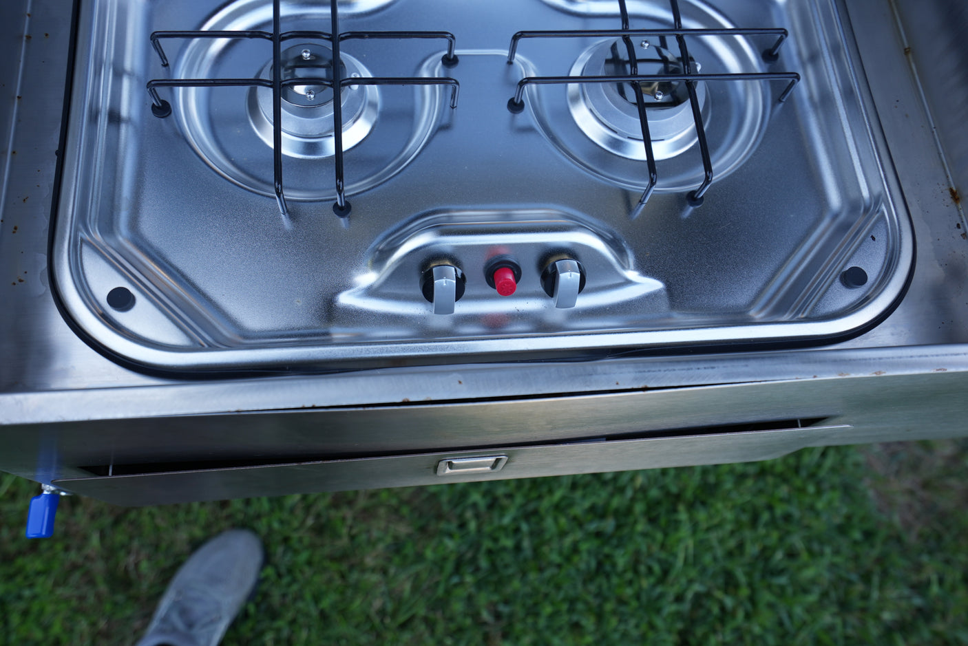 A compact, two-burner stainless steel gas stove with ignition and control knobs, perfect for cooking in this RV rental.