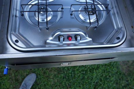 A compact, two-burner stainless steel gas stove with ignition and control knobs, perfect for cooking in this RV rental.