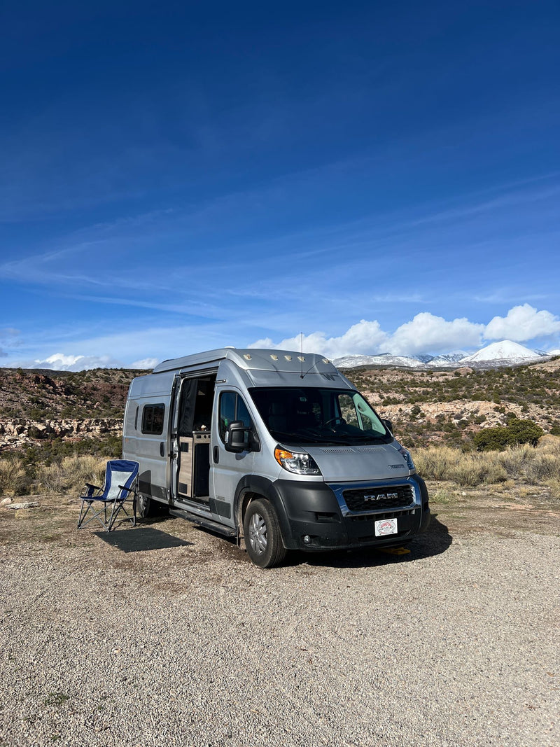  with golden light from low sun behind trees & frosted grass.|Silver Winnebago Solis camper van with pop-top roof extended — photo 3