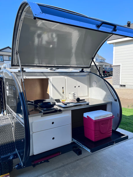  showing its bed interior & rear kitchen galley setup.|This RV rental shows an outdoor kitchen: stainless counter