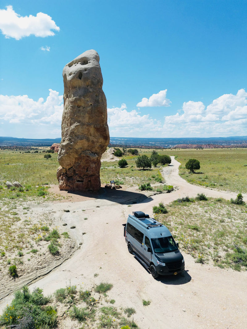  parked on pavement amidst unique red rock formations under a blue sky.|Gray Mercedes Sprinter rv rental on a dirt road — photo 5