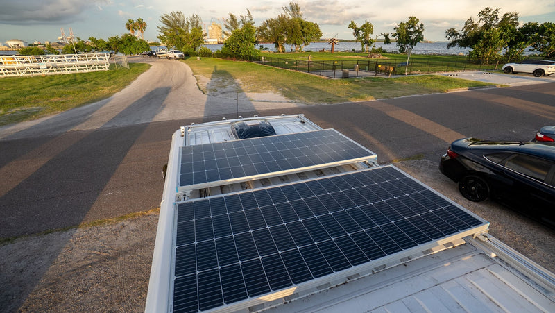 Rooftop view from an RV rental, featuring solar panels, a road, waterfront park, and distant industrial area. — photo 4