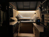 Cozy RV rental interior with comfy seating, ambient lighting, and storage. Perfect for travel!