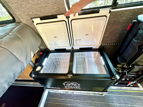 An open dual-zone portable fridge/freezer in an **RV rental** camper van, ready for your adventure food and drinks.