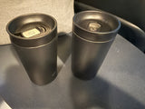 Two dark travel mugs inside an RV rental, ready for road trips or camping adventures.