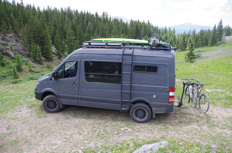 Gray camper van RV rental in a serene forest, carrying bikes & a kayak. Ready for your next outdoor adventure. — photo 11