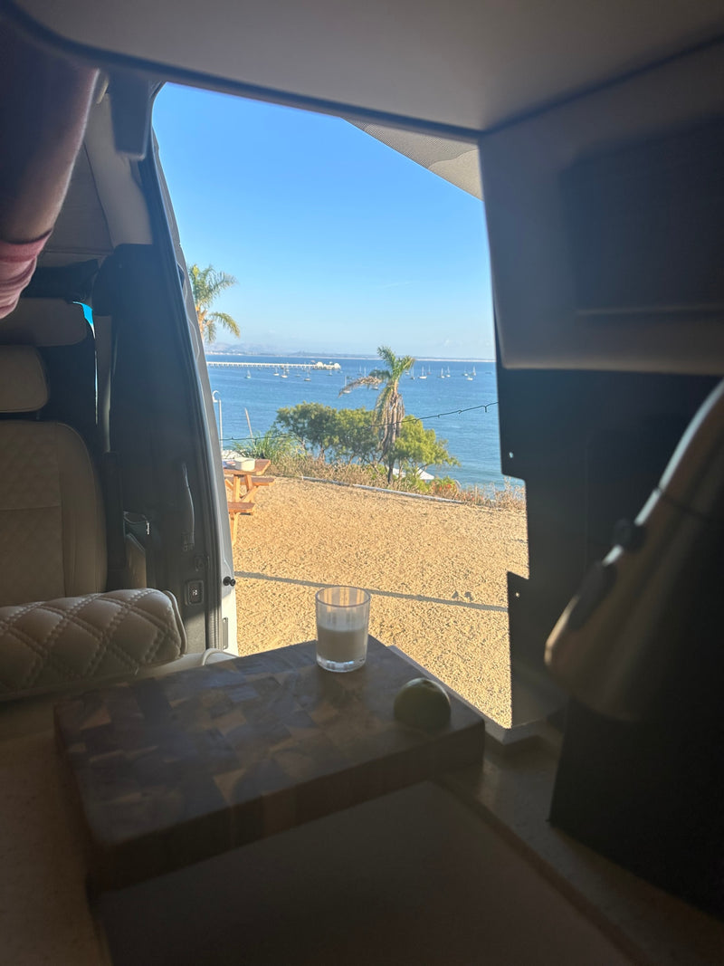 RV rental morning view: tranquil ocean, sailboats, and a refreshing drink with lime on a cutting board. Relaxing travel. — photo 17