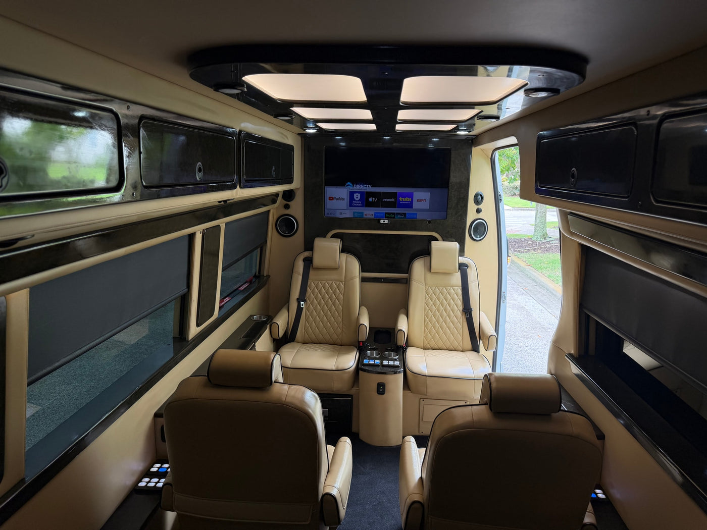 Experience luxury in this RV rental's spacious interior: tan captain's chairs, large TV with streaming apps, and custom ceiling lights. — photo 12