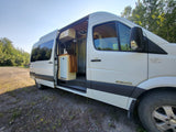 White Sprinter camper van, side door open, shows custom interior. Ready for your next RV rental adventure!