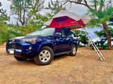 Blue SUV with a rooftop tent and ladder ready for camping. An RV rental alternative, perfect for overland adventures and nature trips.