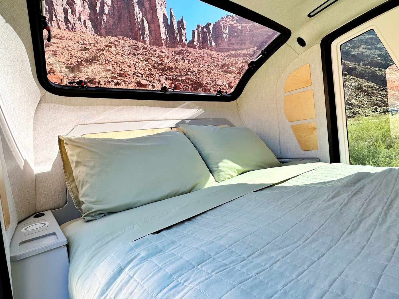 RV rental: Inside a modern camper with a comfy bed & scenic window view of red rocks. — photo 3