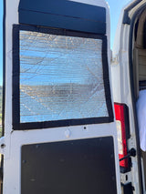 Reflective window insulation for an RV rental campervan conversion, providing privacy and temperature control for van life.