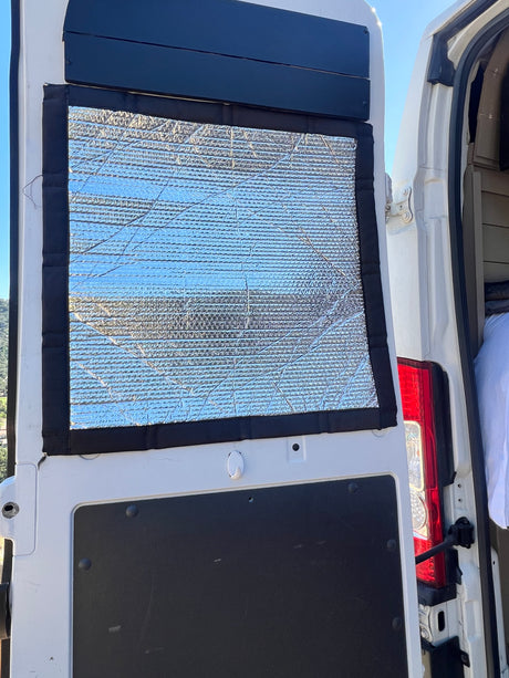 Reflective window insulation for an RV rental campervan conversion, providing privacy and temperature control for van life.
