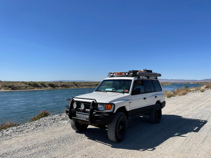 Custom white SUV parked by a river, ready for overlanding. An ideal RV rental for off-road adventure and exploration. — photo 7