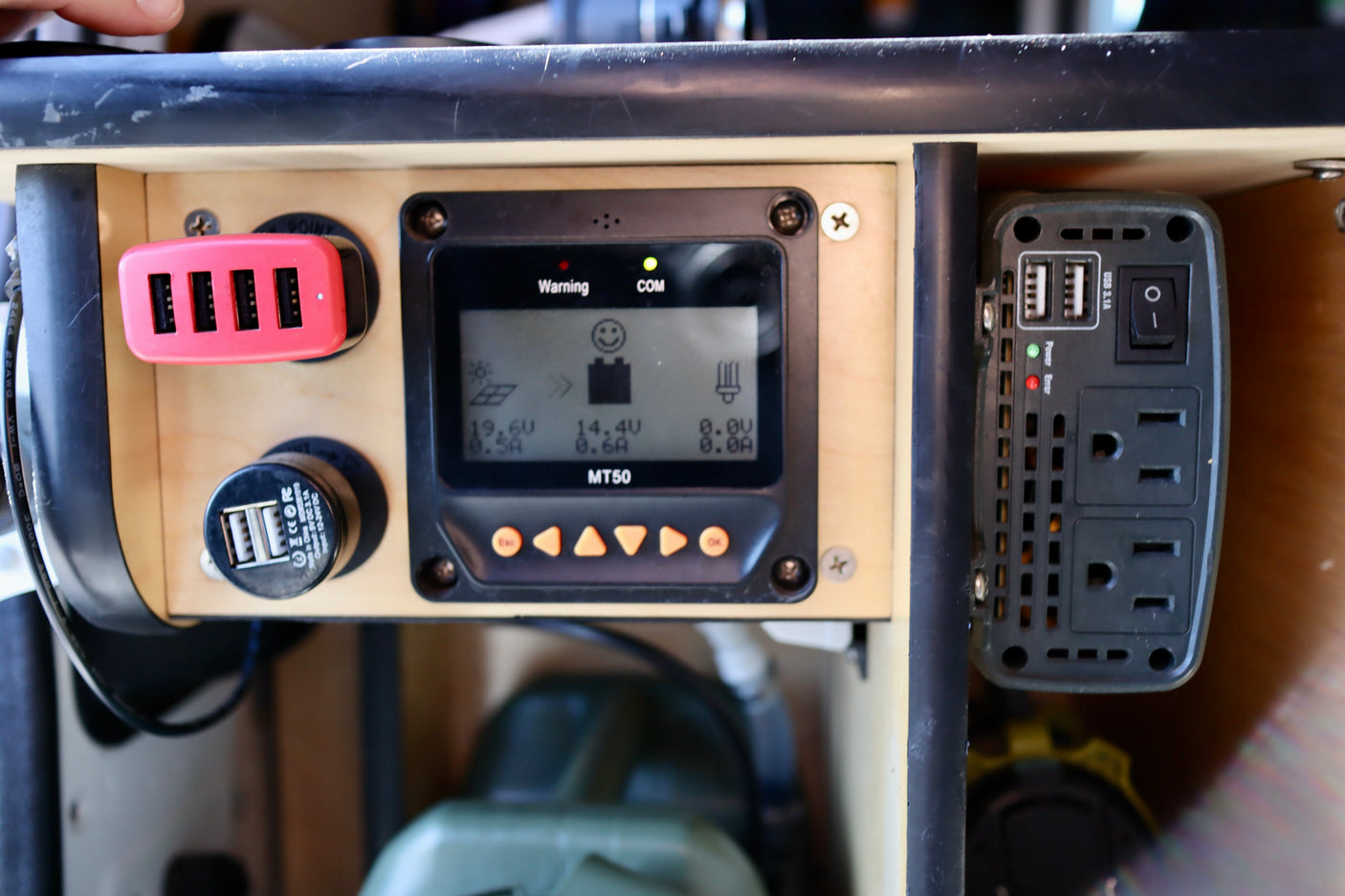 This RV rental power setup includes a solar charge controller (MT50 display), multi-USB chargers, and an AC power inverter. Ideal for portable energy.