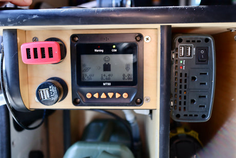 This RV rental power setup includes a solar charge controller (MT50 display), multi-USB chargers, and an AC power inverter. Ideal for portable energy.