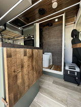This rv rental's modern interior boasts a kitchenette, raised bed, and a smart shower/composting toilet setup for comfort.
