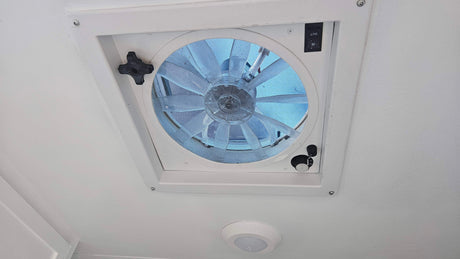 RV rental interior: A white ceiling features a large vent fan with mesh screen, fan speed dial, and directional switch.