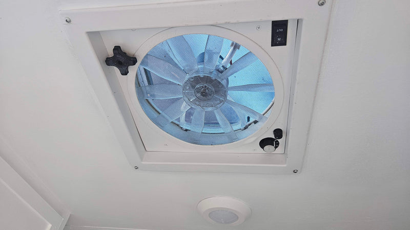 RV rental interior: A white ceiling features a large vent fan with mesh screen, fan speed dial, and directional switch. — photo 15
