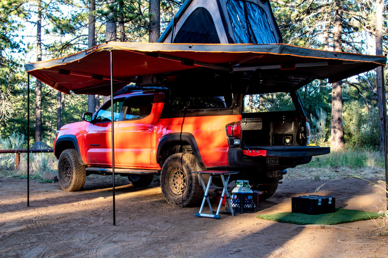 Red Toyota Tacoma with rooftop tent & awning setup for adventure. Perfect for your next overland rv rental trip!|Adventure-ready red Toyota Tacoma truck with an open rooftop tent and awning. An ideal RV rental for overlanding and truck camping.|Orange Tacoma overlander with pop-up tent & open bed storage in a sunny forest. Perfect RV rental alternative for adventure.|Vibrant orange Toyota Tacoma with an open rooftop tent — photo 10