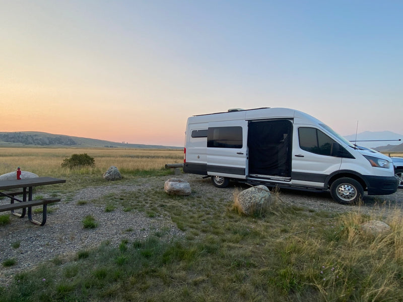 RV rental camper van parked at a peaceful camping spot with a picnic table — photo 1