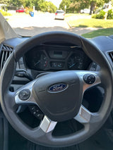 Driver's view from an RV rental van, showing the Ford steering wheel, dashboard, and a clear road ahead.