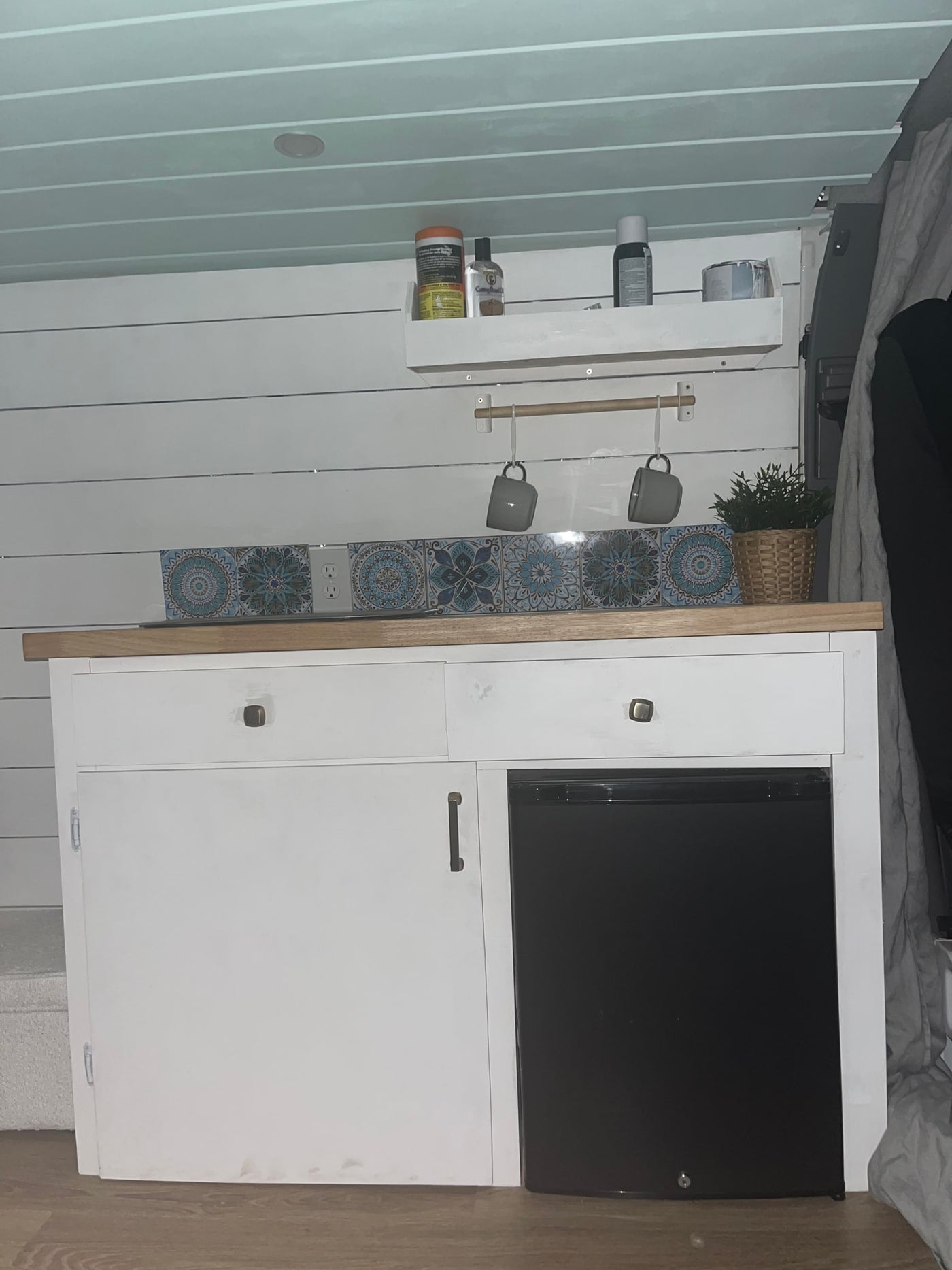 Compact RV rental kitchen featuring white cabinets, mini-fridge, and tiled backsplash, designed for small space living. — photo 3